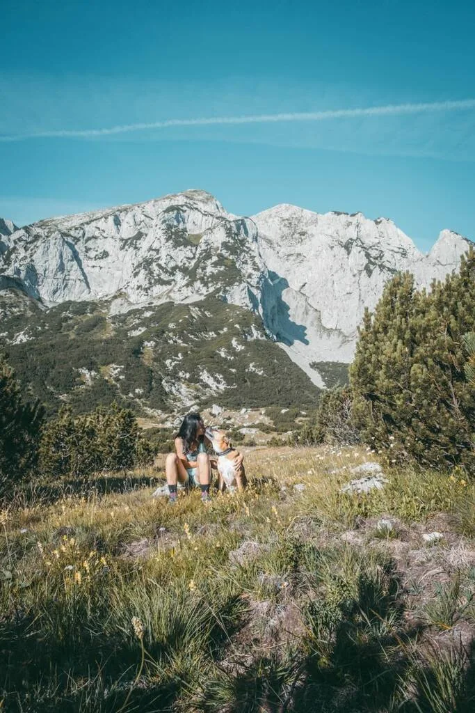 Une femme et son chien devant les montagnes de Bosnie-Herzégovine