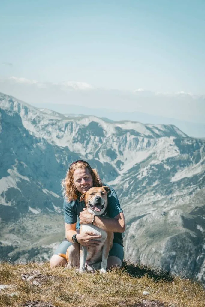 Un homme et son chien devant les montagnes de Bosnie- Herzégovine