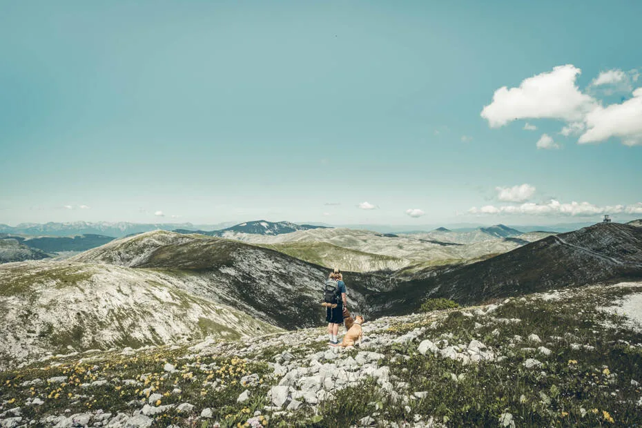 un homme et son chien devant un paysage de montagne à Bjelasnica en Bosnie-Herzégovine