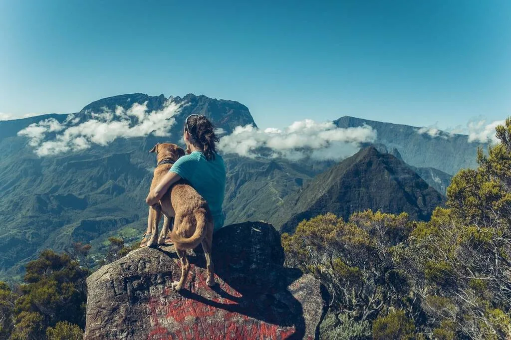 Femme avec son chien devant une vue sur les cirques de La Réunion.