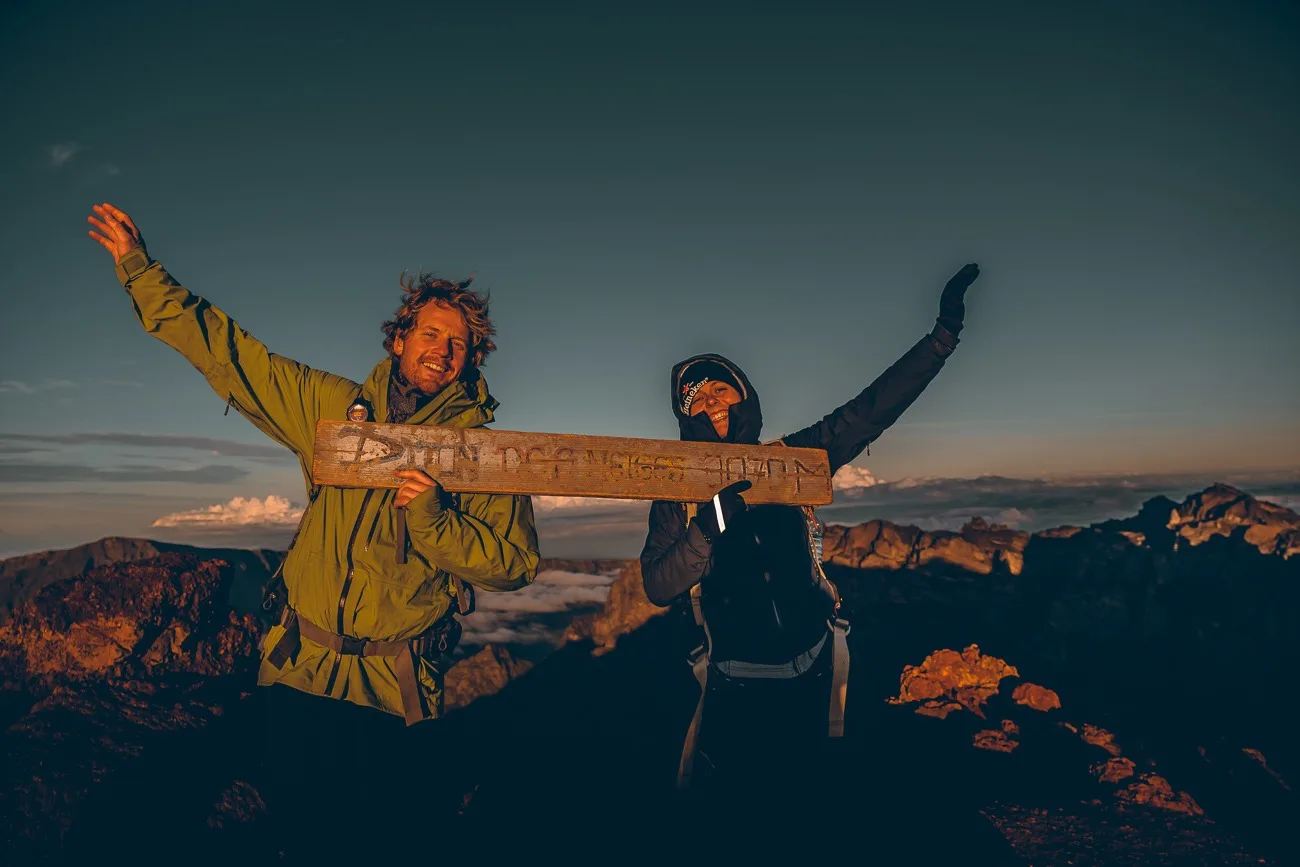 Deux personnes avec le panneau du Piton des Neiges 3070 M à la Réunion
