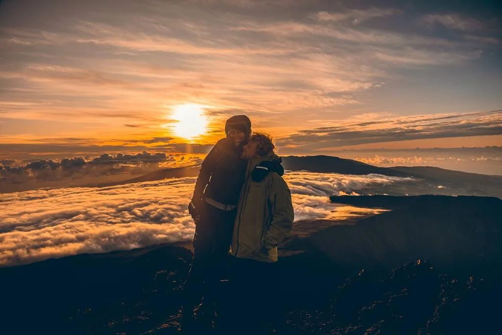 Couple au sommet du Piton des Neiges au lever du soleil à La Réunion.