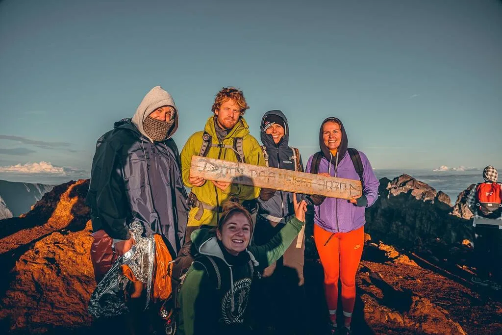 Groupe de personnes avec le panneau du Piton des Neiges 3070 M à la Réunion