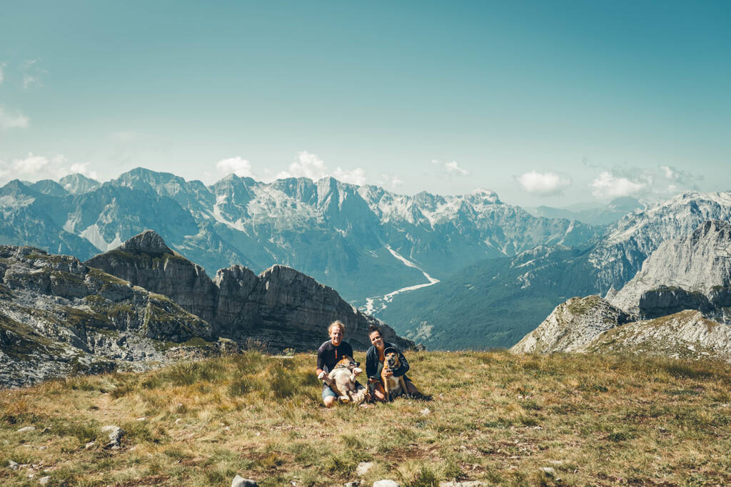 2 personnes avec deux chiens devant une vue du parc de Biogradska Gora située au Monténégro