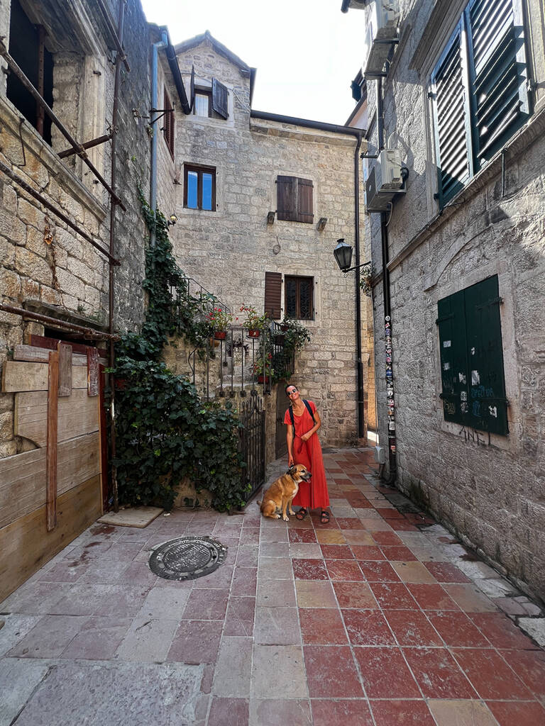 une femme et un chien dans une ruelles de Kotor au Monténégro